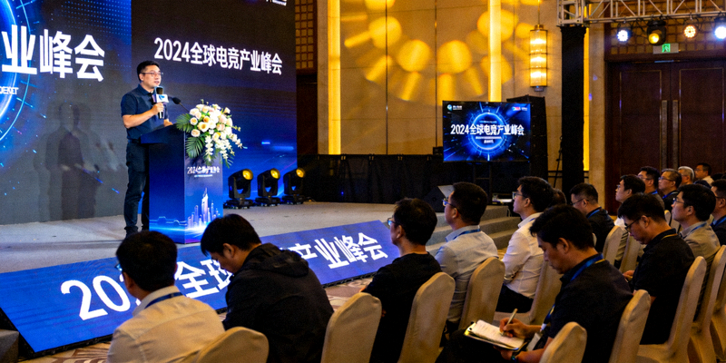 电竞产业峰会现场，行业专家在台上发表演讲，观众认真聆听