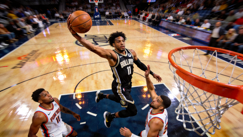 NBA后卫球员运用娴熟技巧突破两人防守，完成高难度拉杆上篮