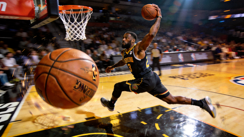 NBA球员在季后赛中完成战斧式劈扣的精彩瞬间，身体舒展，力量感十足