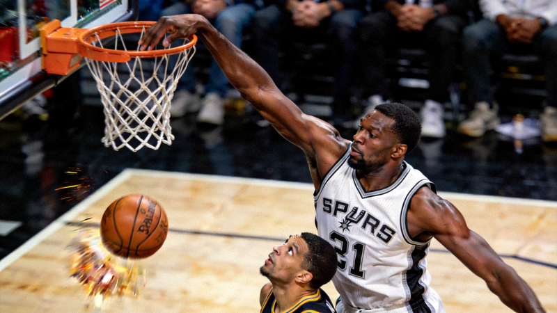 NBA中锋球员高高跃起，将对手势在必得的投篮狠狠扇飞出界外