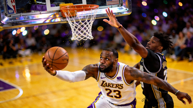 NBA球员突破上篮完成绝杀，防守球员试图封盖但未能成功